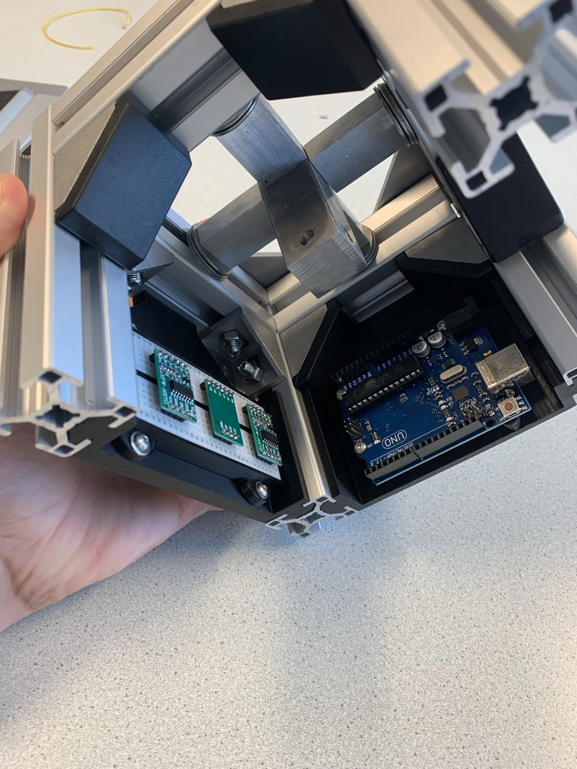 Interior of the accelerometer showing aluminium beams, a central steel mass, circuit boards and an Arduino UNO.