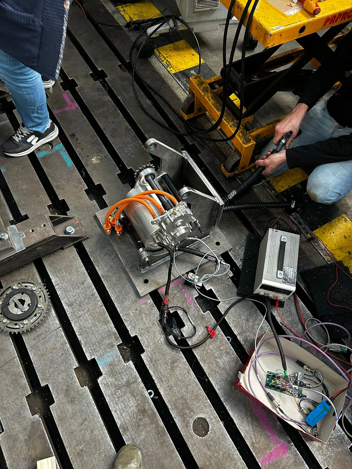 Electric motor with orange power cables, instrument wiring and a metal mounting frame.