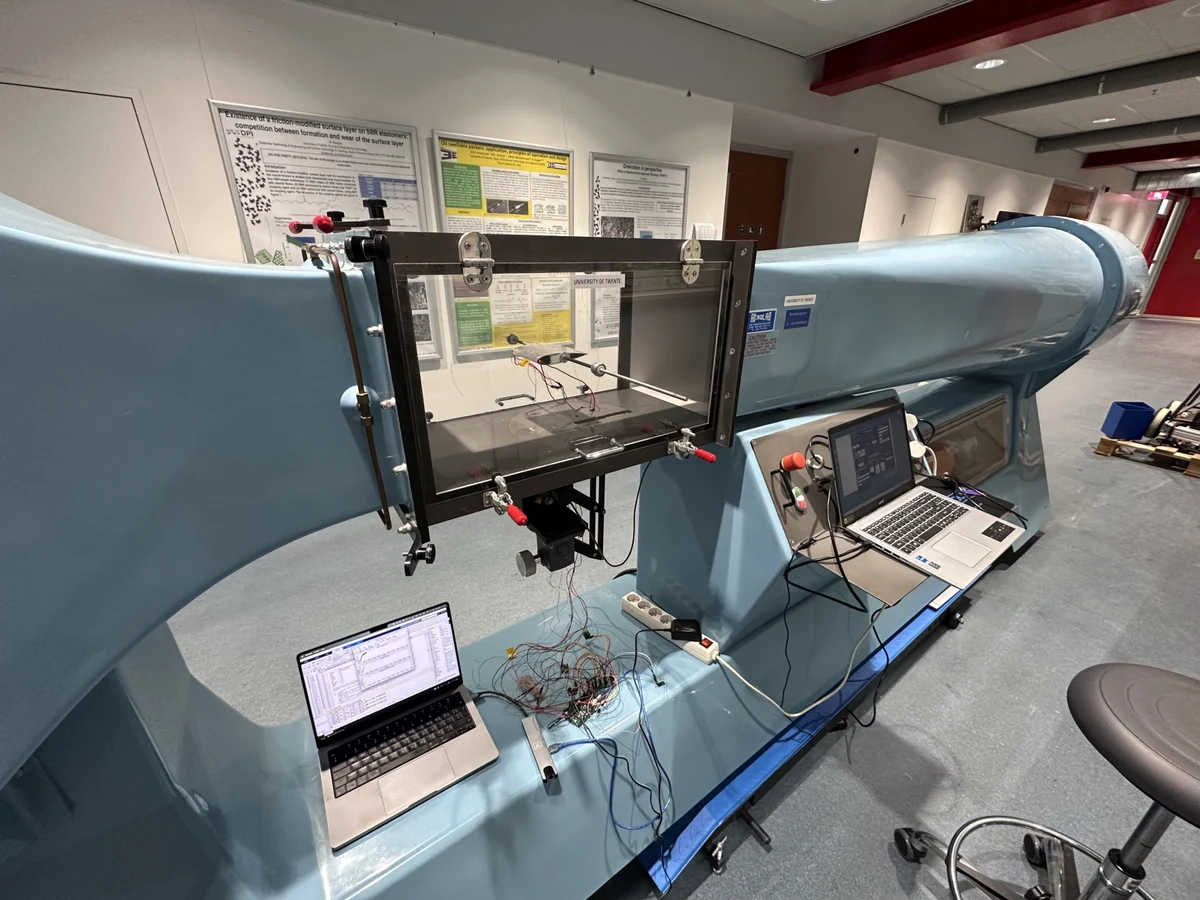 Wind tunnel with an instrumented test section, measurement wiring and laptops.